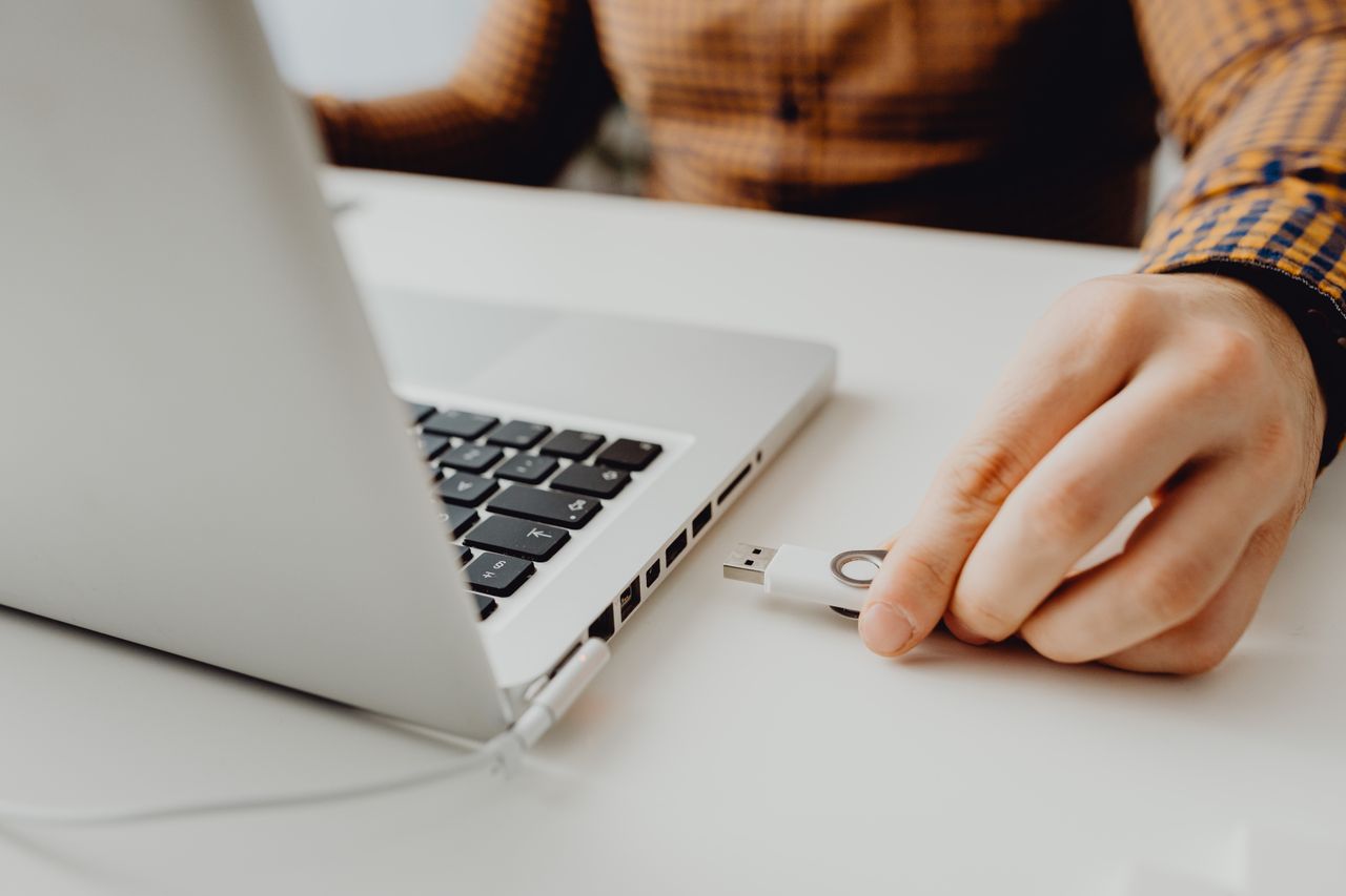 Une personne range ses fichiers sur un ordinateur portable dans un bureau, en quittant Google Drive