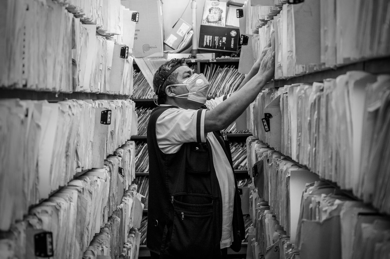 Employee scanning paper documents in an office to archive them