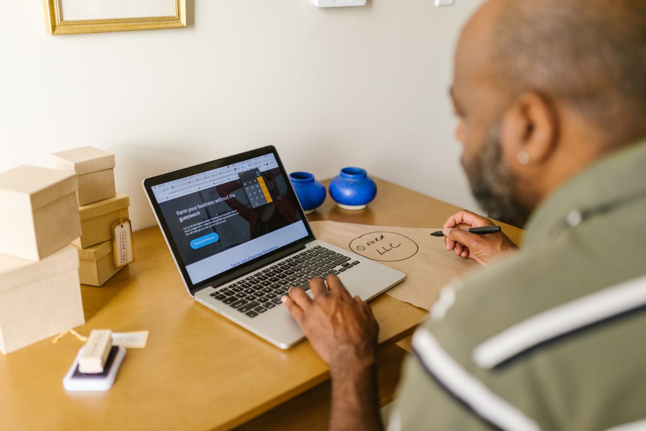 A small business owner preparing invoices on a laptop